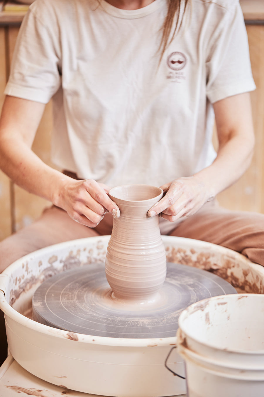 Mains qui font de la poterie sur un tour de potier 