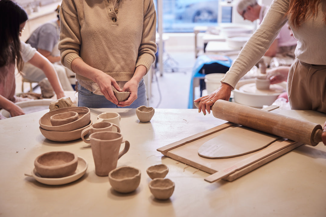 Personnes qui font des pièces en céramique sur une table avec de l'argile