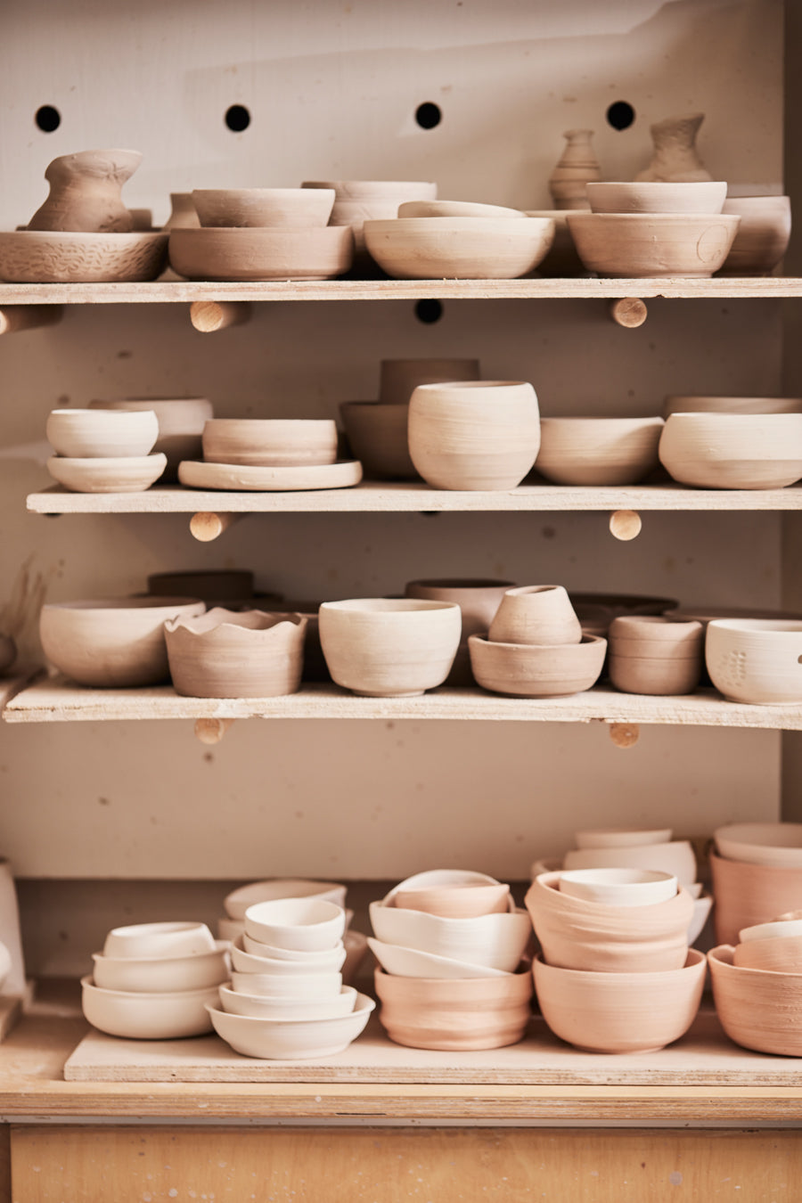 Pièces de poterie qui sèches sur des planches dans un atelier